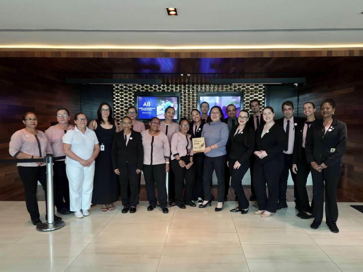 Equipe do Mercure Uberlândia reunida no saguão do hotel, enquanto integrantes seguram placa oficial da Certificação ESG Pulse 2026.